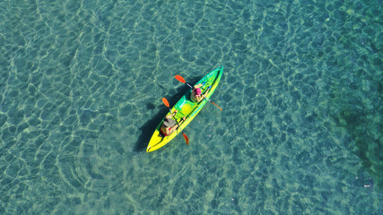 Wall Mural - Aerial drone photo of 2 women canoeing in tropical Caribbean turquoise sea