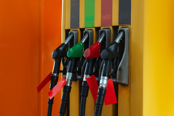 Gas station close-up with colored fuel hoses.