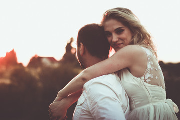 Two lovers on a romantic trip see off the sunset on the outdoor.