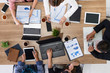 © InfiniteFlow - Top view of businessman executive in group meeting with other businessmen and businesswomen in modern office with laptop computer, coffee and document on table. People corporate business team concept.