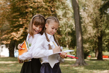 School children doing homework in nature..Schoolgirls have fun in the park