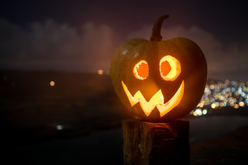 Halloween pumpkin smile and scrary eyes for party night. Close up view of scary Halloween pumpkin with eyes glowing inside at black background.