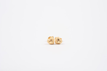 gold earrings in the shape of a heart on the white background.