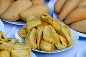 Fresh jackfruit slices on a white plate. Sweet yellow jackfruit ripe. Vegetarian, vegan, raw food. Exotic tropical fruit in Thailand