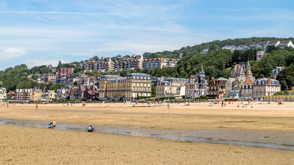 Wall Mural - Panoramic view of the beach of Trouville and beautiful luxury buildings along the beach at low tide. Famous resort and fishermen village in Normandy, France. 