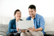 © nuiiko - Asian man teaching his mother using laptop at home, technology concept.