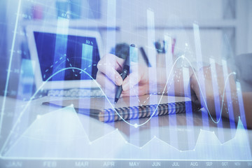 Financial graph displayed on woman's hand taking notes background. Concept of research. Double exposure