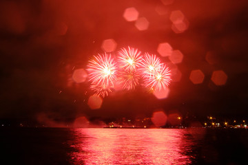 Beautiful colorful fireworks in sky over river. Big festive evening event with great pyrotechnic show.  