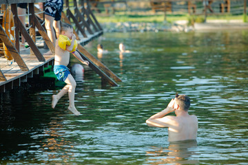 father with kid having fun in water swimming together