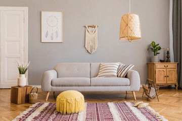 Wall Mural - Stylish and design home interior of living room with gray sofa, wooden cube, commode, pillow, macrame, yellow pouf, rattan lamp, basket, plants and elegant accessories. Stylish home decor. Template. 