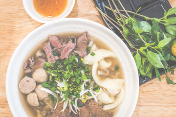 Special Beef vietnamese pho with soup and beef slices, brisket, beef balls, fish maw, scallions served with herbs