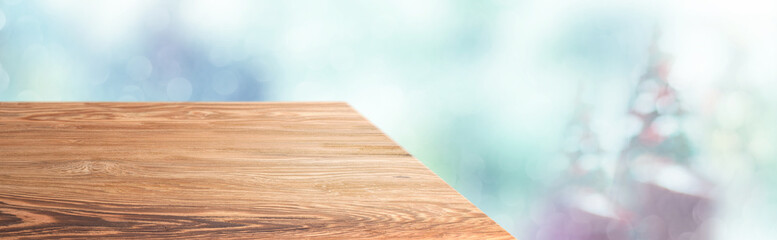 Leinwandbilder - Perspective wood table with blur Christmas tree decorate string light and blue bokeh with snow light.Panoramic wooden countertop banner mock up for product display greeting card design online content