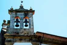 Belfry In The Form Of An Open Wall With Two Bells. The Background Image Is Blue. Copy Space.