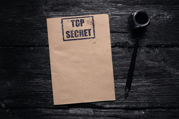 Wall Mural - top secret information or message template. blank brown paper page with a stamp above on a black woo