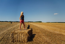 Portrait Of  Beauty Blonde Caucasian Woman Standing On Redneck Of Straw With Backpack