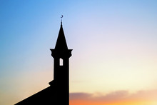 Dark Silhouette Of A Muslim Mosque With A Crescent On The Spire At Sunset