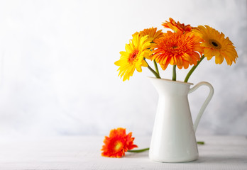 Poster - Beautiful bouquet of red and yellow flowers in white vase on wooden table, front view. Autumn still life with flowers.