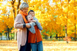 © soleg - Happy family posing, playing and having fun in autumn city park. Children and parents together having a nice day. Bright sunlight and yellow leaves on trees, fall season.