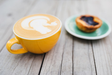 Selective focus on a yellow cup with coffee - rustic breakfast