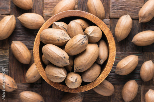 Cuadros en Lienzo shelled pecan nuts raw in wooden bowl, top view.