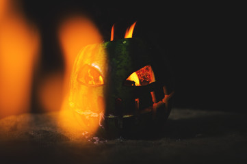 green watermelon burns with fiery flame on the scary holiday of october halloween