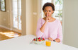 © Krakenimages.com - Young african american woman having healthy breakfast in the morning at home asking to be quiet with finger on lips. Silence and secret concept.