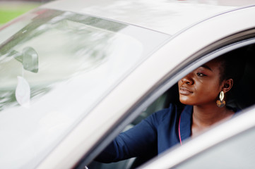 Rich business african woman sit on driver seat at silver suv car with opened door.