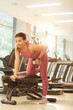 © Seventyfour - Full length portrait of beautiful young woman lifting dumbbells in gym during fitness workout, copy space