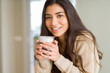 © Krakenimages.com - Beautiful young girl drinking a cup of coffee at home and smiling