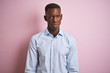 © Krakenimages.com - African american man wearing blue elegant shirt standing over isolated pink background skeptic and nervous, frowning upset because of problem. Negative person.