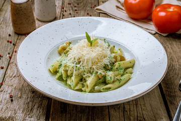 Canvas Print - Pasta Penne in pesto sauce with shrimps on old wooden table