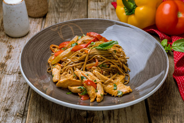 Sticker - chicken wok noodles on old wooden table