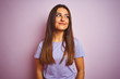 © Krakenimages.com - Young beautiful woman wearing casual t-shirt standing over isolated pink background smiling looking to the side and staring away thinking.