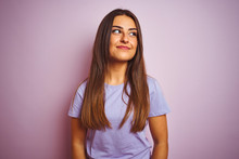 Young Beautiful Woman Wearing Casual T-shirt Standing Over Isolated Pink Background Smiling Looking To The Side And Staring Away Thinking.
