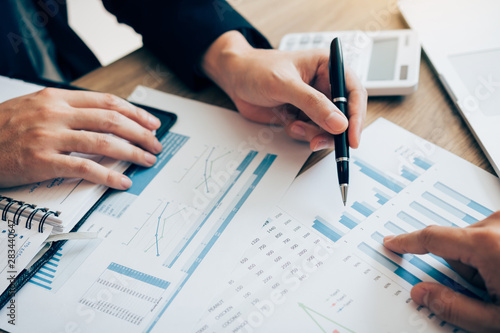 Fotomural The accounting staff of the company are jointly analyzing the graph of the expenses on the desk in the office