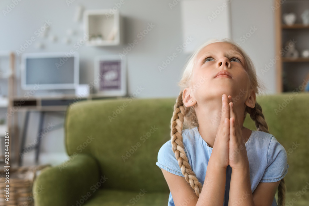 Little girl praying at home