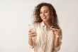 © Pixel-Shot - Beautiful African-American woman with credit card and mobile phone on light background