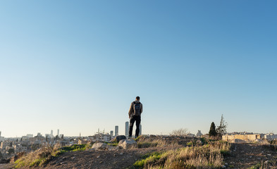 Wall Mural - a man standing on mountain top looking clear sky in jordan