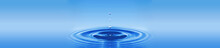 Image Of A Water Drop On A Blue Background..Circles On The Water Diverge From A Drop Of Water