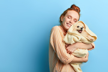 kind friendly girl gets pleasure from hugging her pet. close up portrait, isolated blue background, studio shot.copy space.