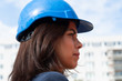 © cineberg - Close up profile portrait of a female engineer wearing a blue protective helmet