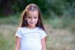 © Khorzhevska - Pretty little girl with long brown hair posing summer nature outdoor. Kid's portrait. Beautiful child's face