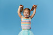 © oes - Portrait of surprised smiling cute little toddler girl. child standing isolated over blue background. Looking at camera and laughs