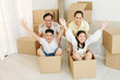 © DragonImages - Happy senior couple playing with their grandchildren in new apartment full of cardboard boxes