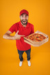 © Drobot Dean - Full length image of attractive delivery man in red uniform smiling and holding pizza box