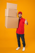 © Drobot Dean - Full length portrait of handsome delivery man in red uniform showing thumb up while carrying packaging boxes