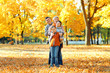© soleg - Happy family posing, playing and having fun in autumn city park. Children and parents together having a nice day. Bright sunlight and yellow leaves on trees, fall season.