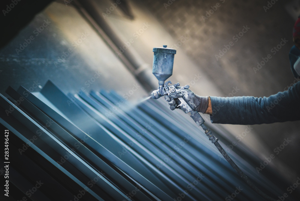 Man painting metal products with a spray gun - obrazy, fototapety, plakaty 