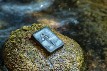 Poster - Norse rune Teihwaz (Tihwaz,Tyr) on the stone and the evening river background. Law, order, protection, nobility, courage. The rune is associated with the Scandinavian god Tür.