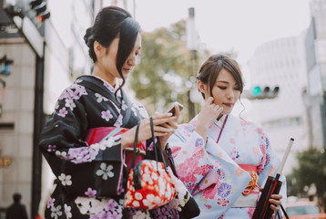 Two japanese girls wearing kimonos traditional clothes, lifestyle moments